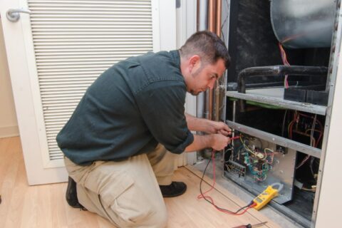 A HAVC Expert repairing a traditional HVAC System in Knoxville, TN