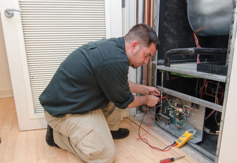 A HAVC Expert repairing a traditional HVAC System in Knoxville, TN